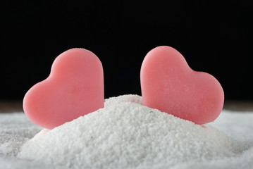 Fototapeta premium Two pink shape heart lay on the sand. love concept.