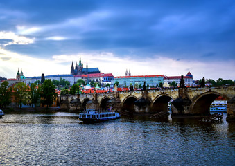 Obraz premium A view of Prague Castle and the Charles Bridge across the Vltava River in Prague, Czech Republic.
