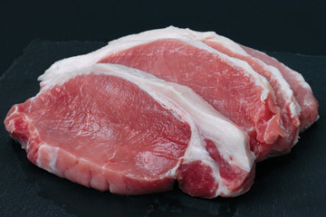 sliced ​​pieces of fresh meat on a black board