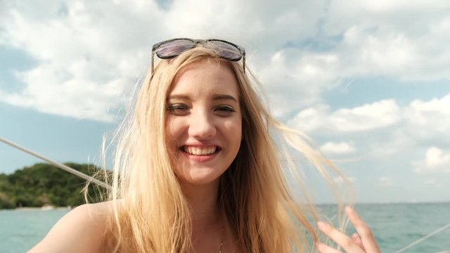 Blond hair Caucasian girl act as selfie herself and also talk to her friend to show her tour.