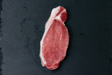 sliced ​​pieces of fresh meat on a black board
