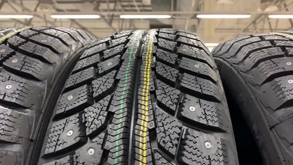 Many new winter tires on shelves.  Car tire wheels storage in the supermarket store.