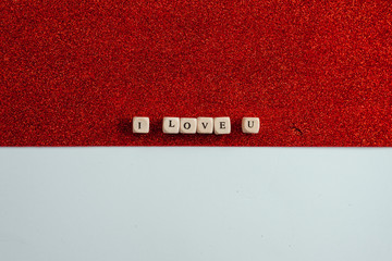 On a shiny red background, the bones are laid out with the phrase: I love you. Concept of Valentine's Day.