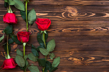 Naklejka na ściany i meble On a wooden surface are red roses