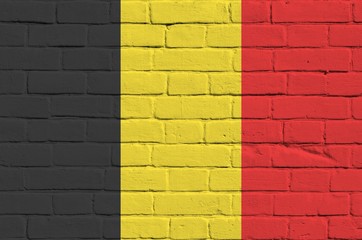 Belgium flag depicted in paint colors on old brick wall. Textured banner on big brick wall masonry...