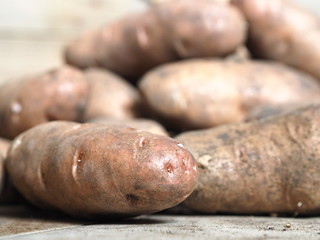 potato tubers on wooden rustic background