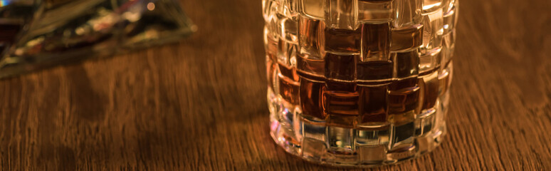 Panoramic shot of glass of brandy on wooden table