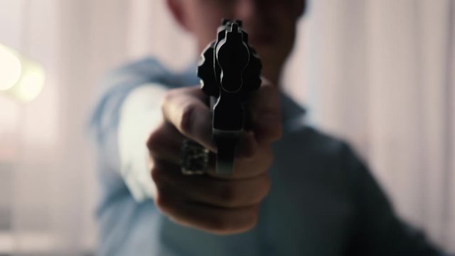 Thug points a gun at the camera