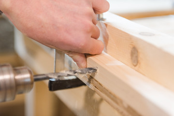drill a hole with a drill. man drills a hole in the board.