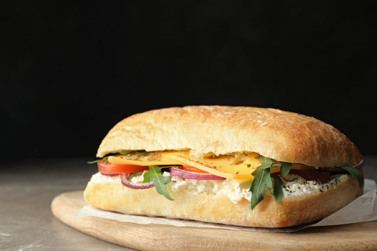 Delicious sandwich with fresh vegetables and cheese on grey table