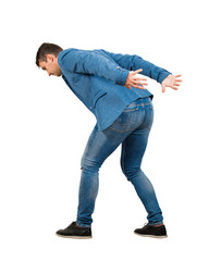 Bent down young man keeps hands back as carrying an heavy invisible object on his shoulders...