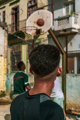 latino kids paying basketball on old court in Havana, Cuba