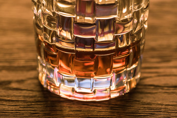 Close up view of brandy in textured glass on wooden table