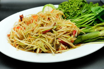 Thai style papaya salad with chilli, tomato and eggplant beside with varity of vegetable using as traditional food and asian hot dish concept.