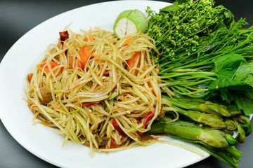 Thai style papaya salad with chilli, tomato and eggplant beside with varity of vegetable using as traditional food and asian hot dish concept.
