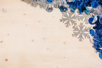 Christmas background. Colored tinsel on a wooden background.