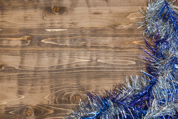 Christmas background. Colored tinsel on a wooden background.