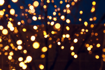 abstract unfocused festive background of Christmas lights garland yellow illumination 