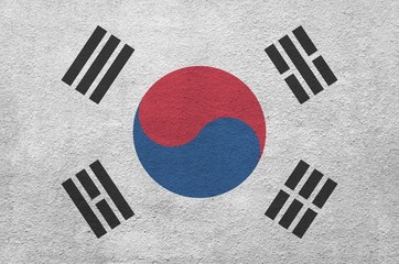 South Korea flag depicted in bright paint colors on old relief plastering wall. Textured banner on...