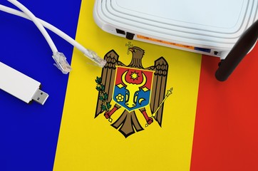 Moldova flag depicted on table with internet rj45 cable, wireless usb wifi adapter and router....
