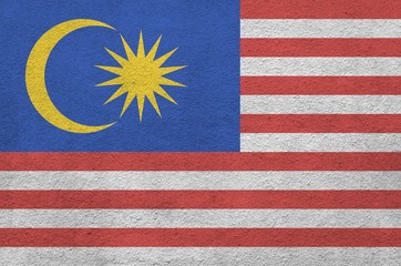 Malaysia flag depicted in bright paint colors on old relief plastering wall. Textured banner on...