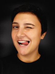 brunette girl with short hair on a black background depicts various human emotions