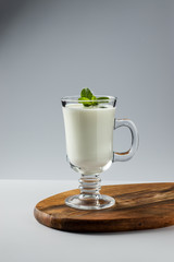 Ayran in a glass, fermented drink, sour milk, decorated with a leaf of mint