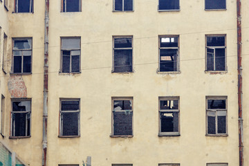 old yellow dilapidated facade of a residential multi storey building