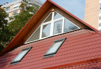 Attic house skylights with panoramic window. Metal roofing on house attic with skylights.