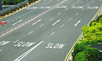 Worded marking SLOW painted on the road every lanes to warn drivers to slow down