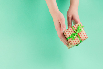 Present in woman hand on a green background.