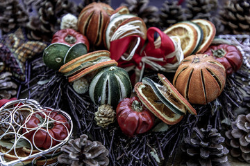 Christmas decoration. Twigs christmas tree, brown natural pine cones and variety of fruits on burlap fabric background.