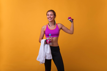 Close up portrait of delightful beautiful ideal slim sportive powerful muscular positive woman dressed in tight pink top demonstrating her biceps. beautiful fitness woman showing her biceps.