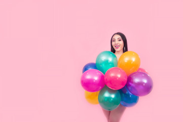 Obraz premium Beautiful young woman holding colorful balloons with surprise face on pink background, Isolated.