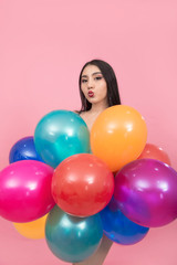 Fototapeta na wymiar Beautiful asian young woman holding colorful balloons with kissing lips on pink background, Isolated.