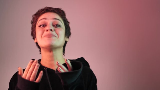 Portrait of a short-haired teenager girl in neon rays. The girl looks directly at the camera 4k