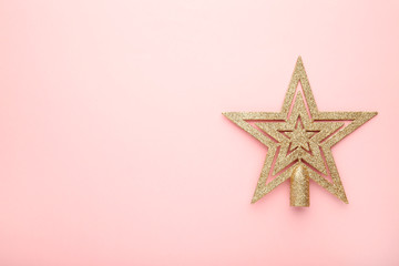 Fototapeta na wymiar Golden glittering star on pink background with copy space