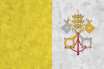 Vatican City State flag depicted in bright paint colors on old relief plastering wall. Textured...