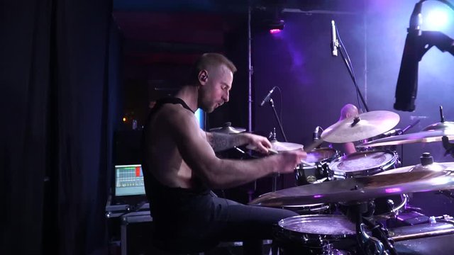 The drummer cool plays the rock concert. The drummer beats the drums on stage. The drummer cool plays the rock concert. The drummer beats the drums on stage. Drummer performing on stage with smoke 