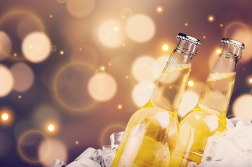 Beer bottles with ice on blurred background