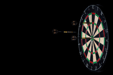 Darts and dartboard on a black background