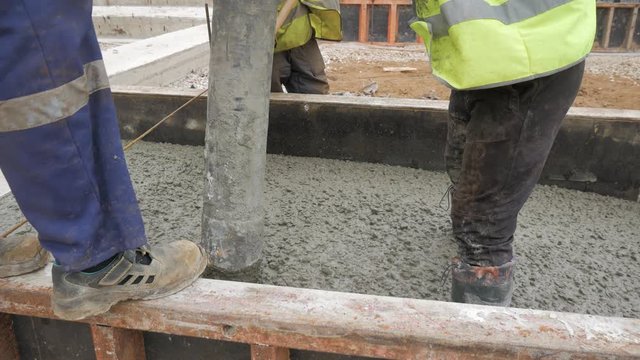 Pouring concrete mix from cement mixer on concreting formwork. Finished leveling the slab and pouring the concrete basement floor. 4K