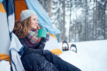 Confident solo woman traveller camping through an evergreen wint