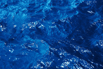 Texture blue sea water with sunny reflections. Classic blue background