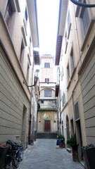 a narrow alley between buildings in Italy with bicycles parked 