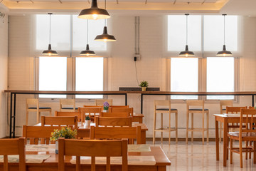Brightness and clearly interior of the restaurant with wooden furniture and window background.