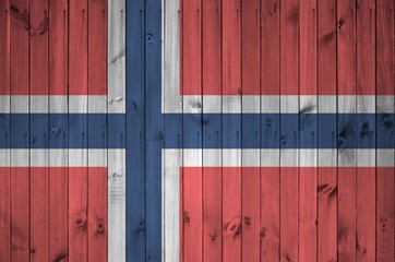 Norway flag depicted in bright paint colors on old wooden wall. Textured banner on rough background