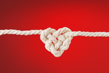 White rope in heart shape knot on background. Love concept.
