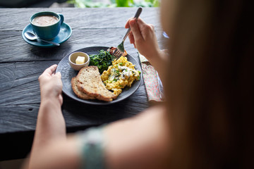 Person on diet eating healthy breakast of scrambled eggs, toast, - 307691114