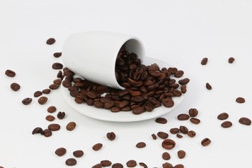 Coffee beans fall out of an overturned mug
